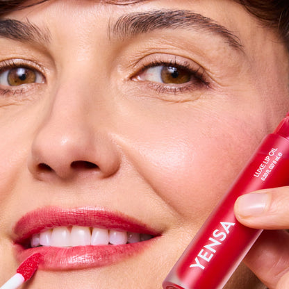 YENSA Luxe Lip Nourishing Oil with Hyaluronic and Vitamin E, featuring a sleek lip oil applicator and vibrant ruby color.