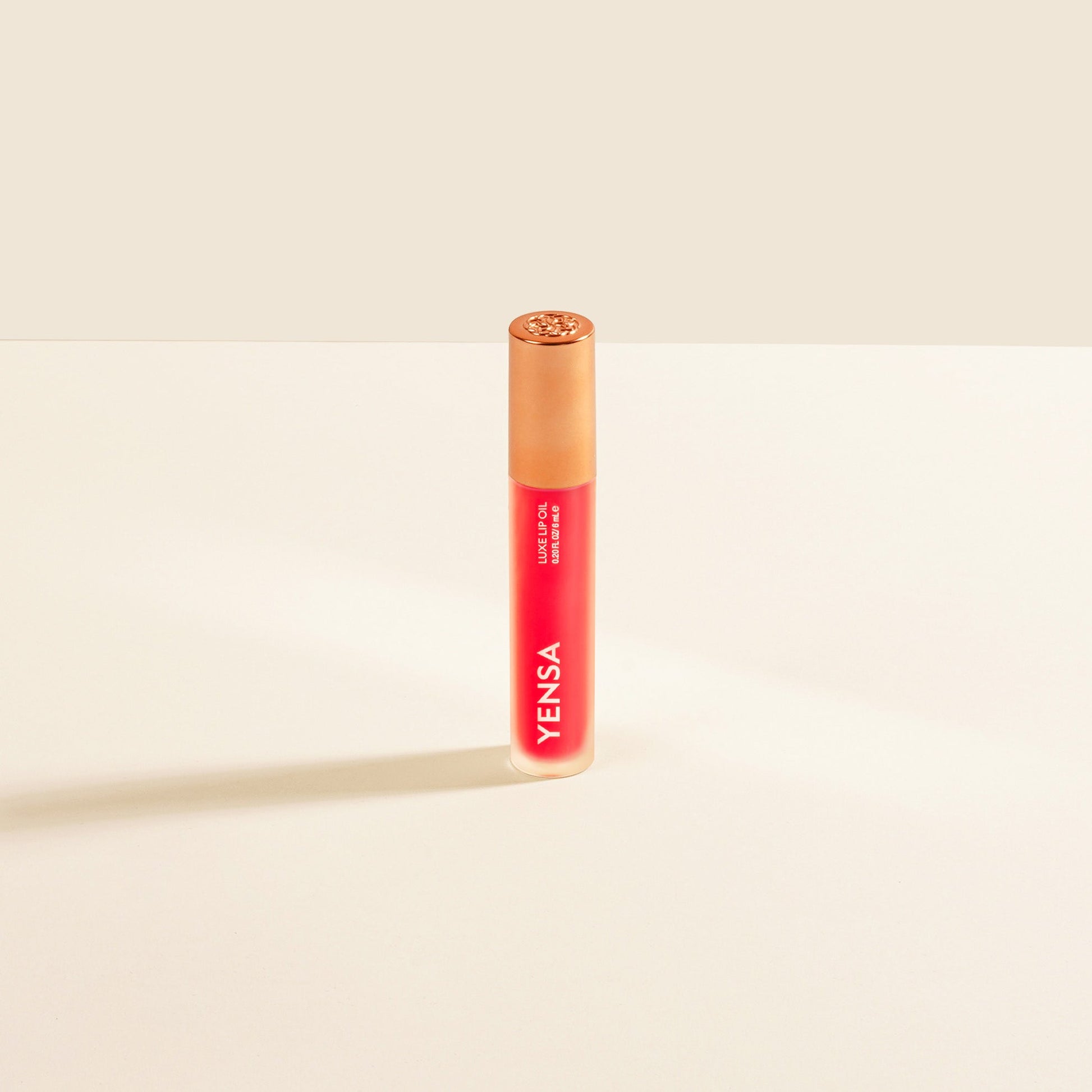 YENSA Luxe Lip Nourishing Oil with Hyaluronic and Vitamin E, featuring a glossy lip oil with a ruby tint in a sleek bottle.