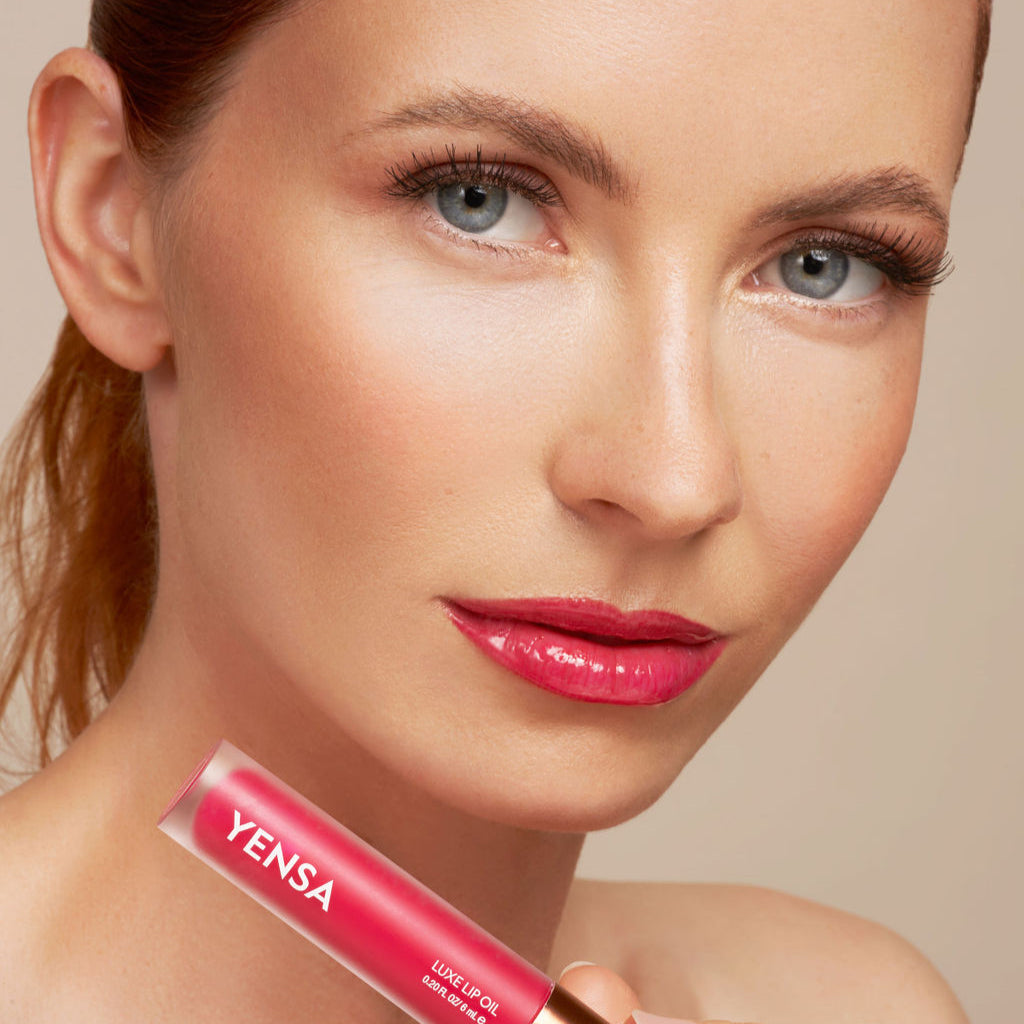 YENSA Luxe Lip Nourishing Oil with Hyaluronic and Vitamin E, featuring a clear lip oil with a hint of red tint in a sleek bottle.