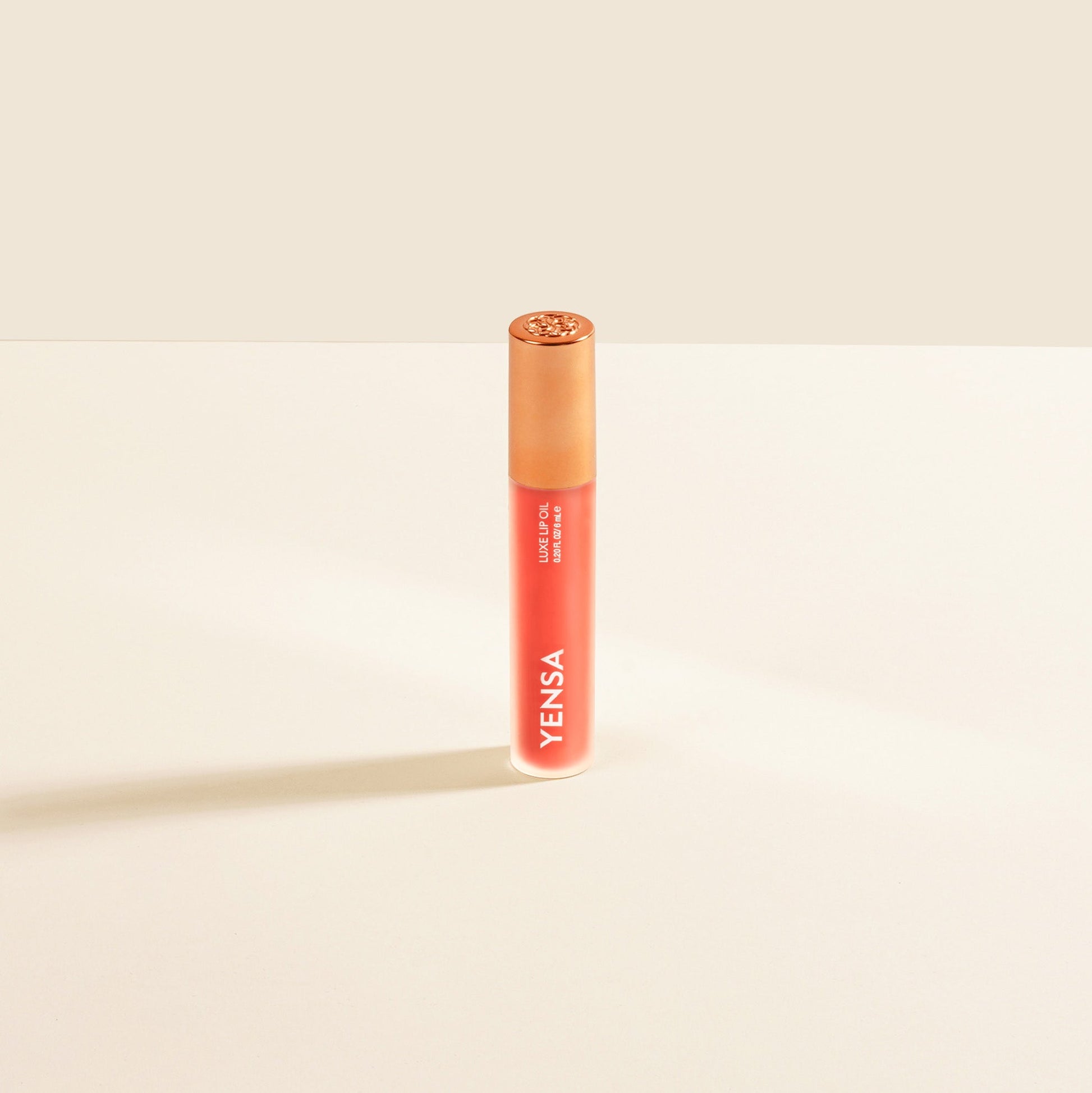 YENSA Luxe Lip Nourishing Oil with Hyaluronic and Vitamin E, showing the sleek lip oil bottle with a ruby-colored tint.