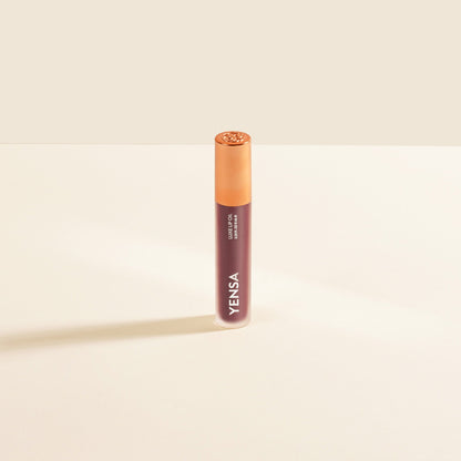 YENSA Luxe Lip Nourishing Oil with hyaluronic and vitamin E, featuring a glossy lip oil in a clear bottle with a red cap.
