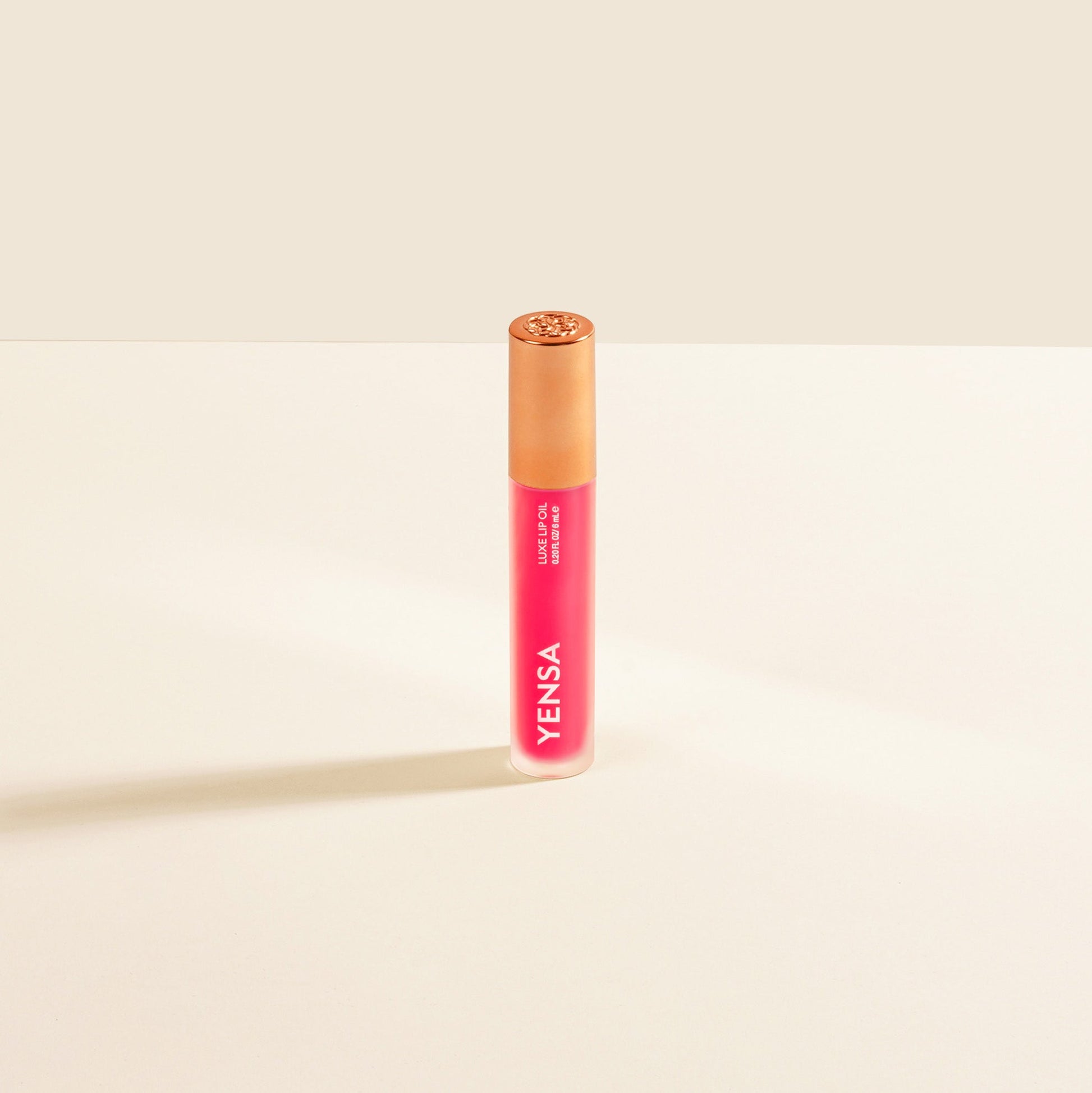 YENSA Luxe Lip Nourishing Oil with Hyaluronic and Vitamin E, featuring a sleek lip oil bottle with a shiny cap and vibrant ruby color.