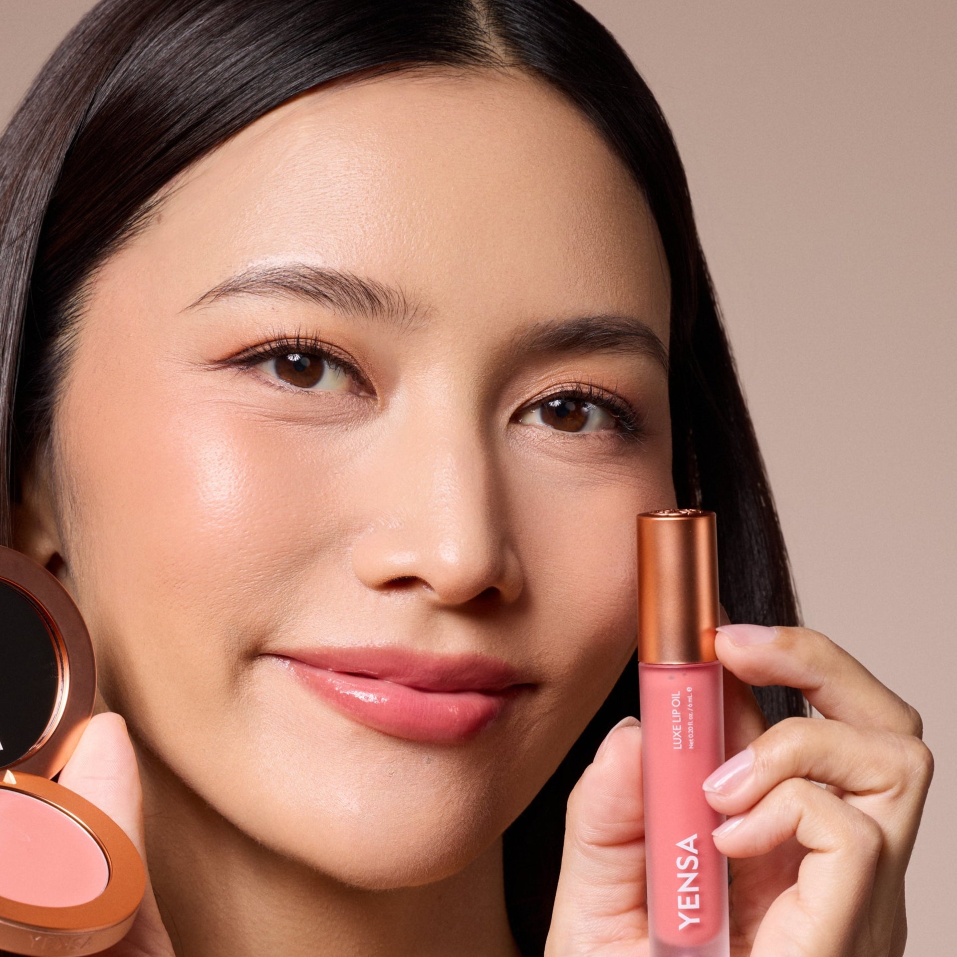 YENSA Luxe Lip Nourishing Oil with Hyaluronic and Vitamin E, featuring a glossy lip oil in a sleek bottle with a ruby tint.