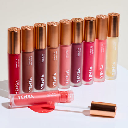 YENSA Luxe Lip Nourishing Oil with Hyaluronic and Vitamin E, featuring a sleek applicator and vibrant ruby-colored lip oil.